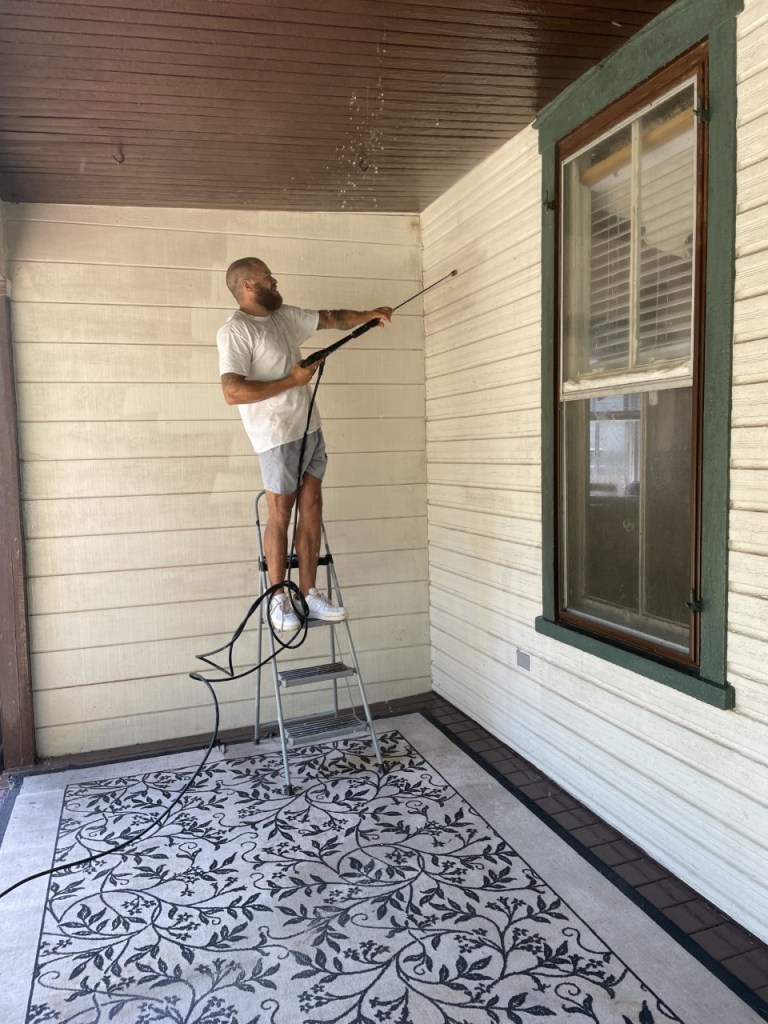 Clark and Sons pressure washing a covered porch